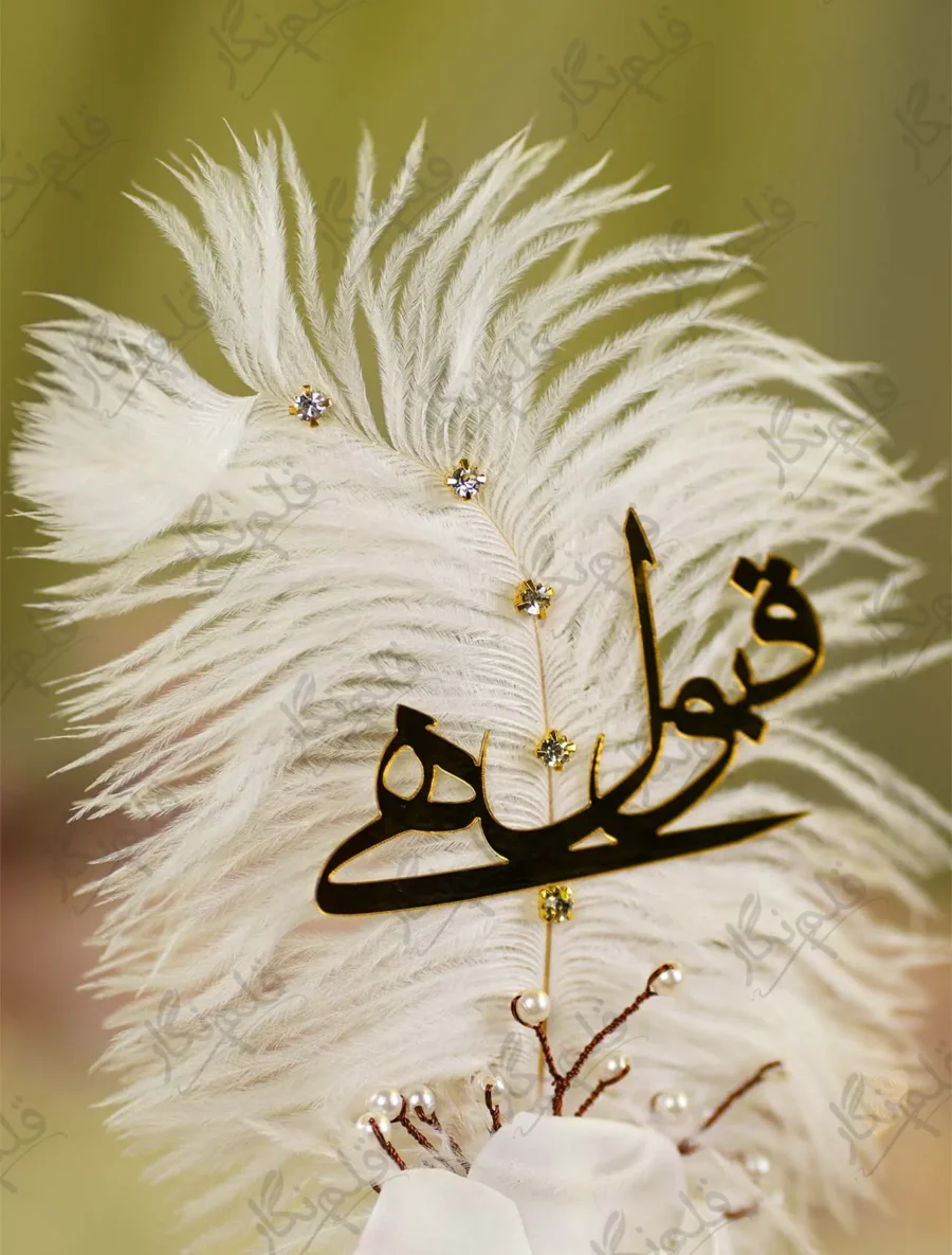Close up of the golden mirror acrylic Qabool Hai script on the white feather
