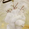 Detailed shot of the hand rolled white satin rose and pearl sprigs