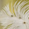 High angle shot of the scattered gold rhinestones on the white feather