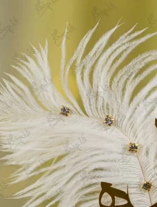 High angle shot of the scattered gold rhinestones on the white feather